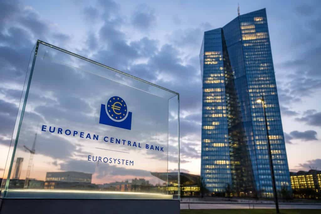Europos centrinio banko pastatas ir ženklas vakare apšviestoje miesto dalyje.